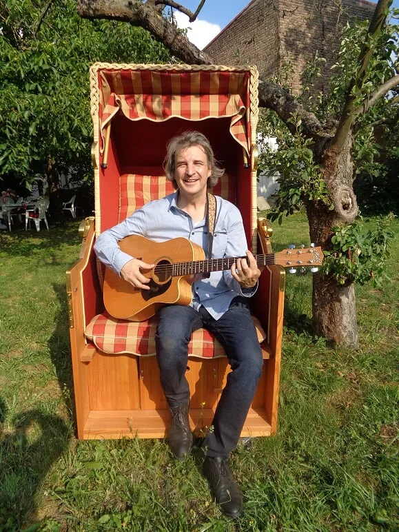 Lukas Mueckenfett mit Gitarre im Garten der Alten Brennerei Ribbeck